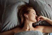 Frau in Bett mit Kopfhörern Frau in Bett mit Kopfhörern
